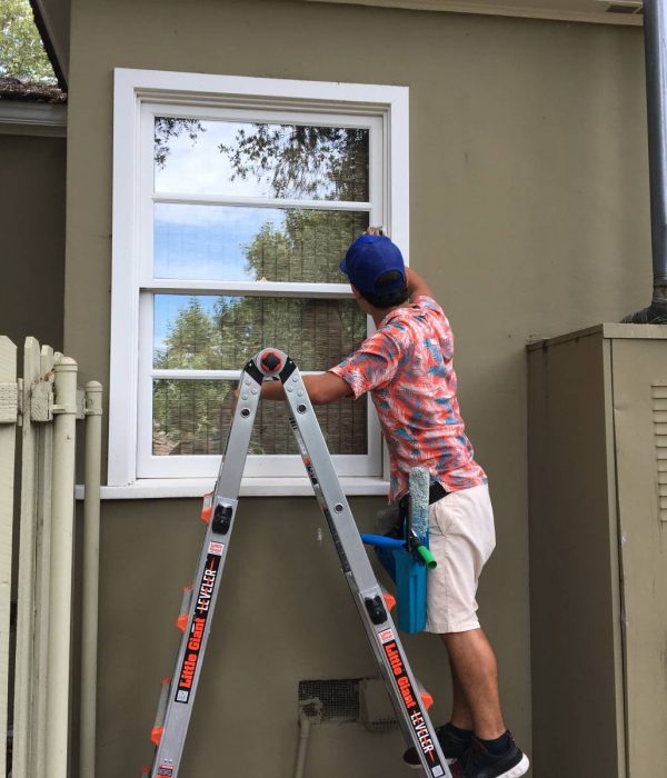 Big Wave Window technician window cleaning on a ladder